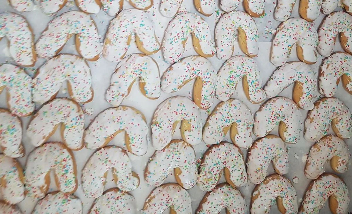 Accene from Alimena coated in white icing and decorated with colourful sugar sprinkles