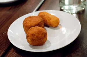 Golden Sicilian potato arancini on a rustic ceramic plate