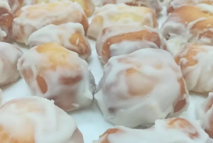 Traditional Catania Regina biscuits glazed with lemon icing on a Sicilian ceramic plate