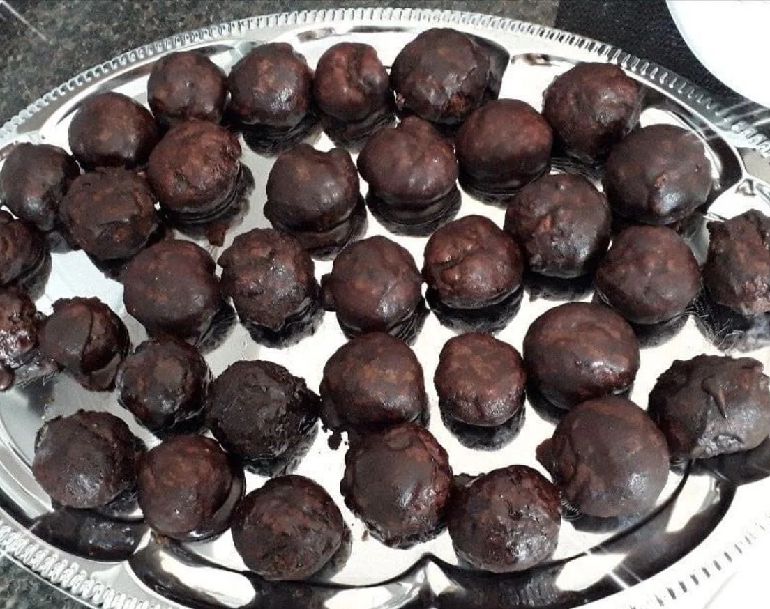 Catania Totò biscuits coated in glossy chocolate glaze on Sicilian ceramic plate