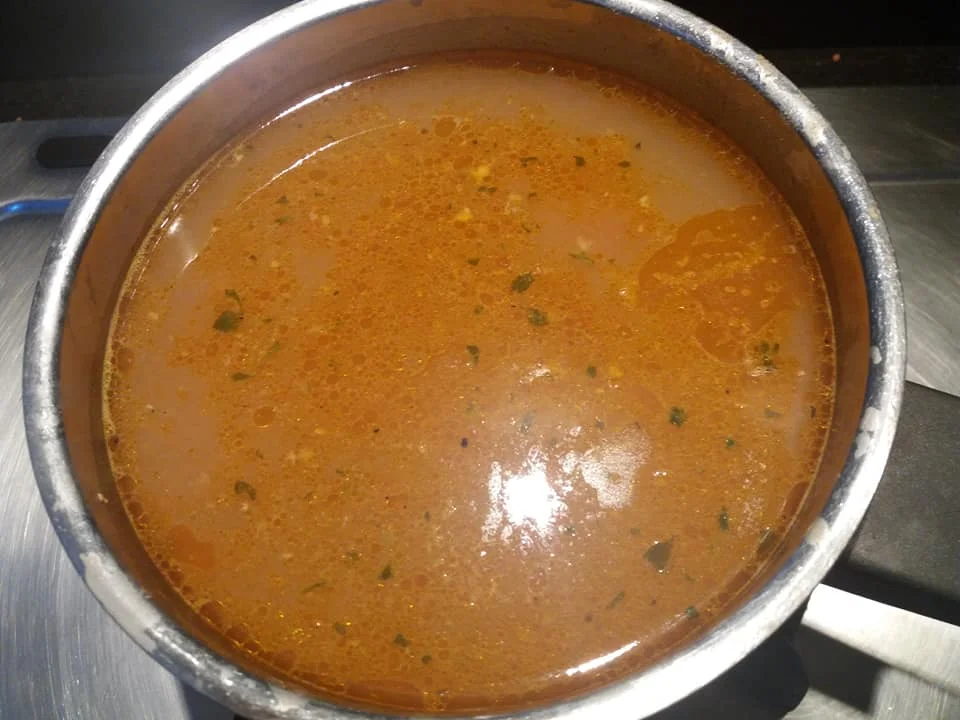 Ciotola di brodo di cernia servita con crostini e prezzemolo fresco