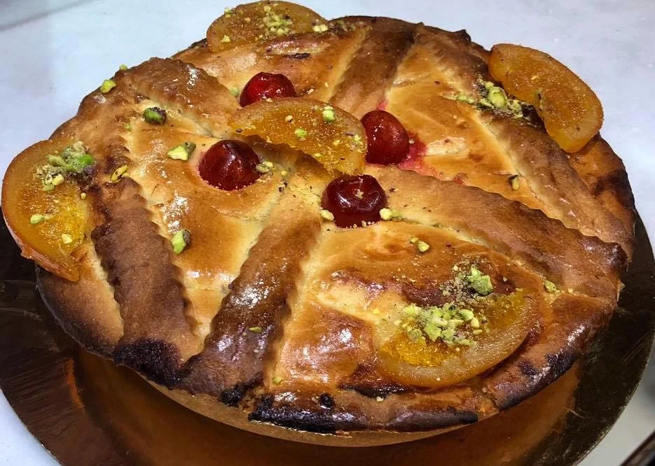 Cassata Costanza d'Aragona decorata con canditi e pistacchi su piatto di ceramica siciliana