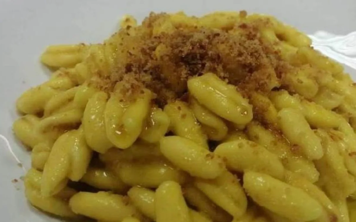 Cavatelli con bottarga di tonno e pepe nero serviti in piatto di ceramica siciliana
