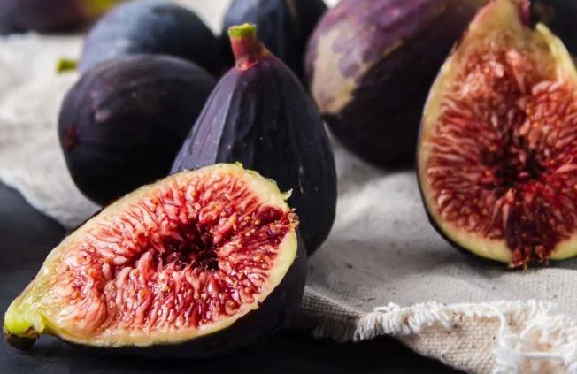 Homemade Sicilian fig jam in glass jars with fresh figs beside them