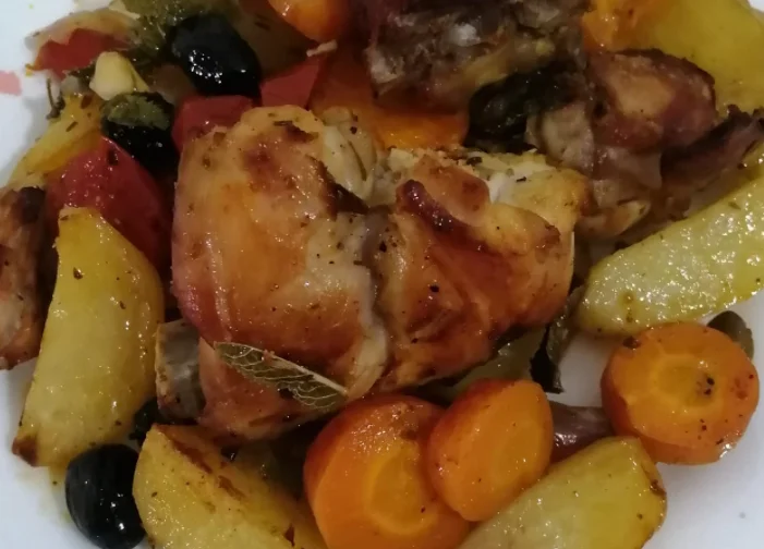 Coniglio â stimpirata servito in piatto di ceramica siciliana con olive e menta