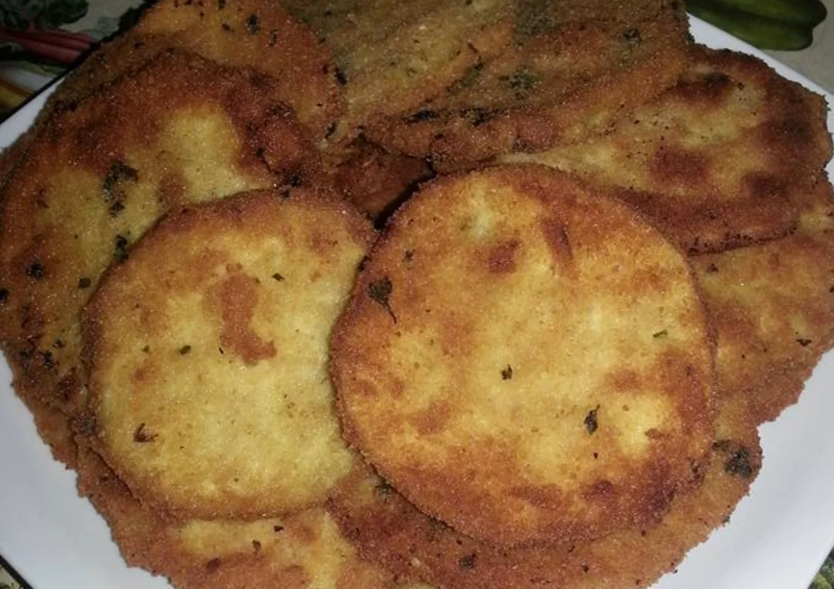 Cotolette di melanzane dorate e croccanti servite su un piatto di ceramica siciliana