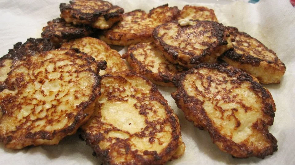 Frittatine di ricotta dorate su piatto di ceramica siciliana con erbe fresche