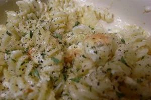 Fusilli cremosi al pesce spada affumicato con prezzemolo fresco su piatto di ceramica siciliana
