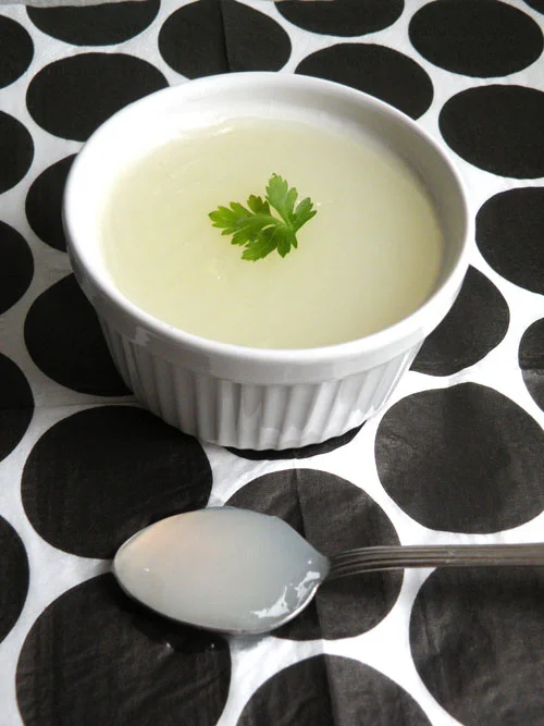 Coppette di gelo di limone guarnite con scorza di limone e foglie di menta su tavolo in ceramica siciliana