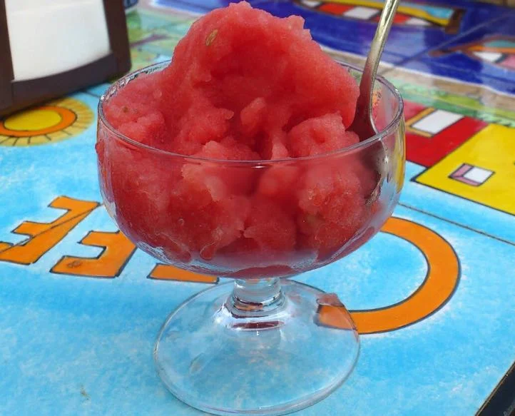 Granita di anguria servita in coppe di vetro, decorata con fettine di anguria fresca