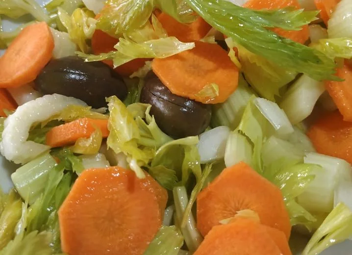 Insalata palermitana con carote, sedano e olive in ciotola di ceramica siciliana
