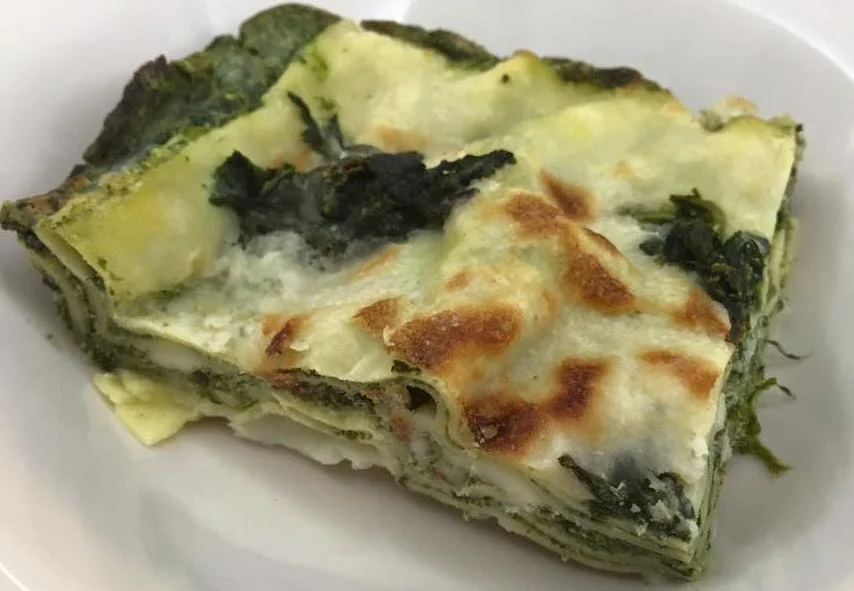 Lasagne con ricotta e spinaci servite in pirofila con crosticina dorata e formaggio filante
