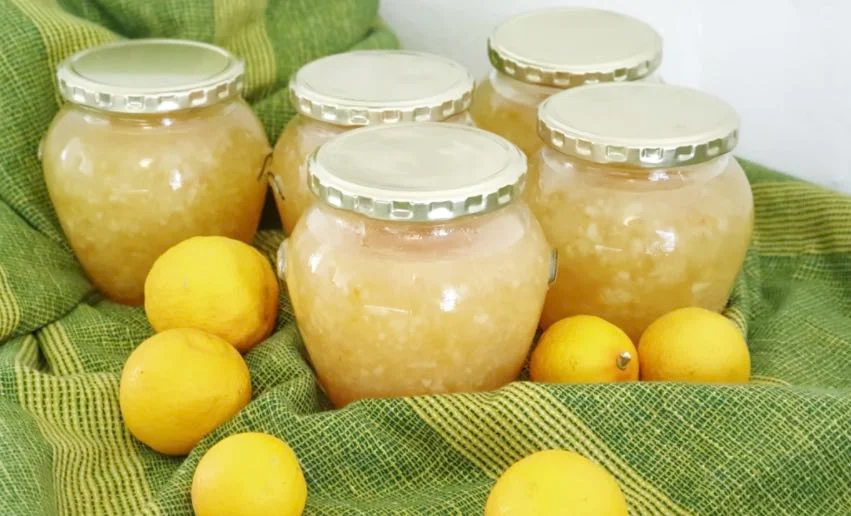 Marmellata di limoni siciliana in vasetto con limoni freschi sullo sfondo