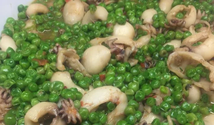 Minestra di seppie con piselli e patate servita in ciotola di ceramica siciliana