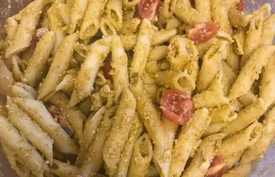 Pasta fredda con crema di pomodorini Pachino e basilico servita in piatto di ceramica siciliana