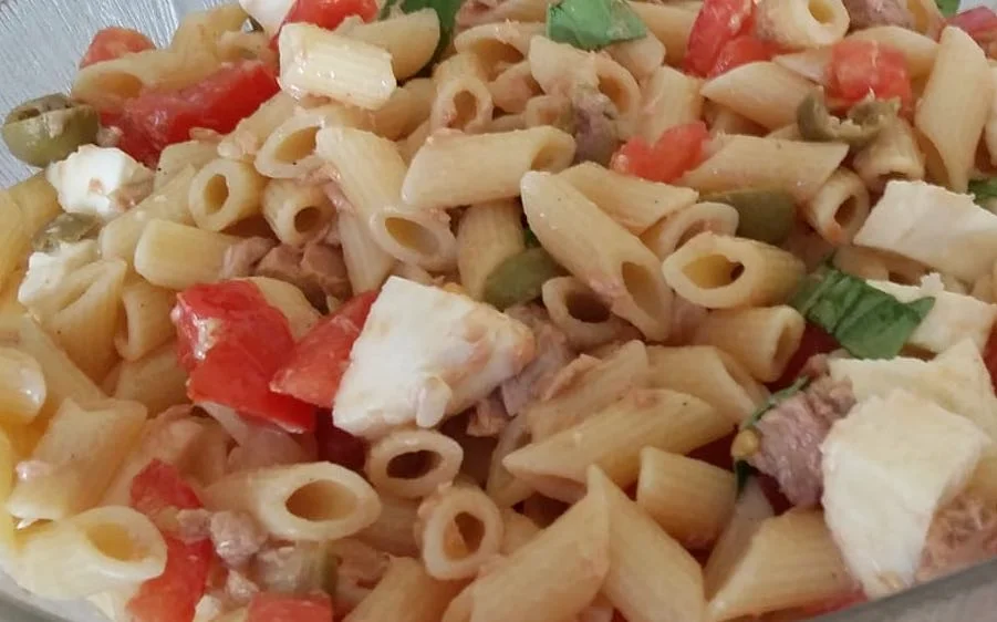 Pasta fredda con tonno, pomodorini e tuma, servita in piatto di ceramica siciliana
