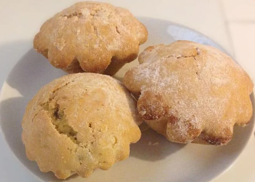 Pasticciotti di zucca eoliani dorati con marmellata di zucca e scorza di limone su vassoio in ceramica