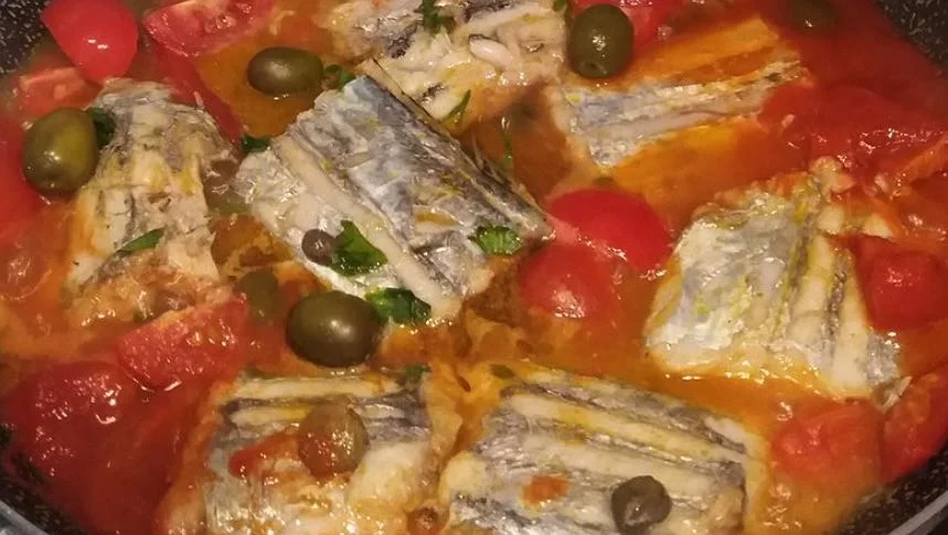 Pesce spatola alla messinese servito in tegame di terracotta siciliana con pomodorini e capperi