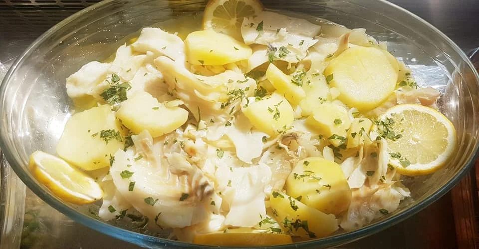 Pesce stocco con le patate in bianco alla messinese servito con limone e prezzemolo