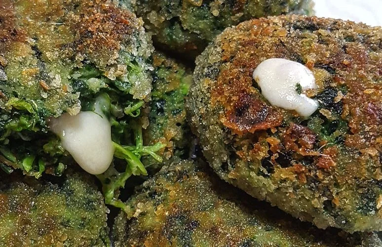 Polpette di spinaci dorate servite su piatto di maiolica siciliana