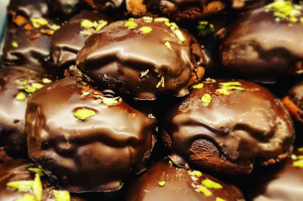 Rame di Napoli ricoperte di cioccolato e pistacchio su piatto siciliano
