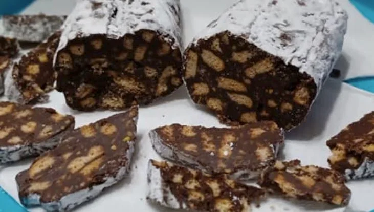 Fette di salame turco siciliano al cacao e biscotti su vassoio