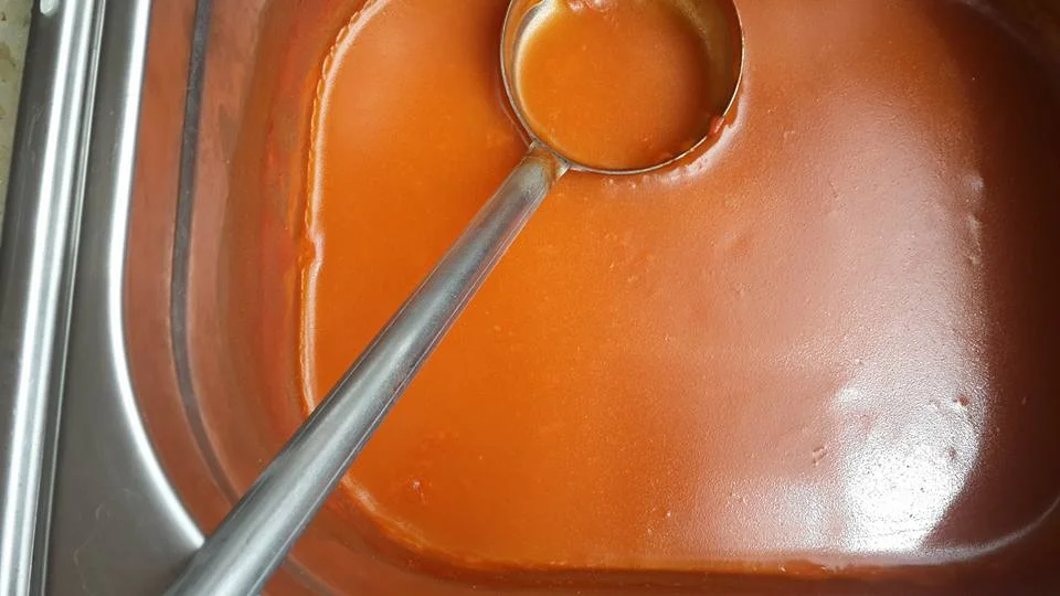 Salsa di pomodoro alla messinese servita in ciotola di ceramica con foglie di basilico fresco