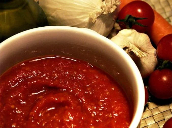 Salsa in agrodolce con le mandorle servita in ciotola di ceramica siciliana