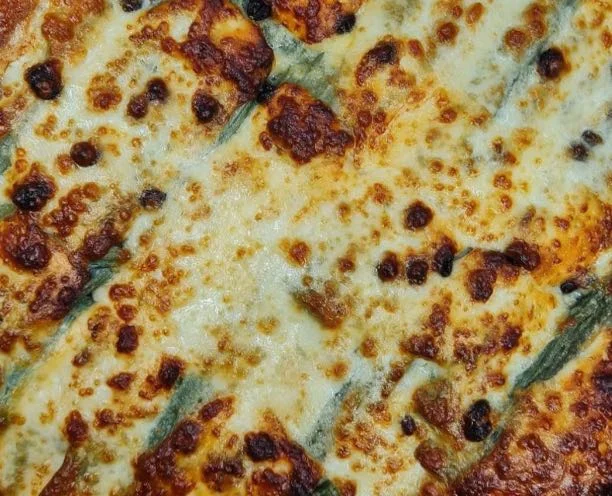 Sformato di cardi siciliano servito su piatto di maiolica con crosticina dorata