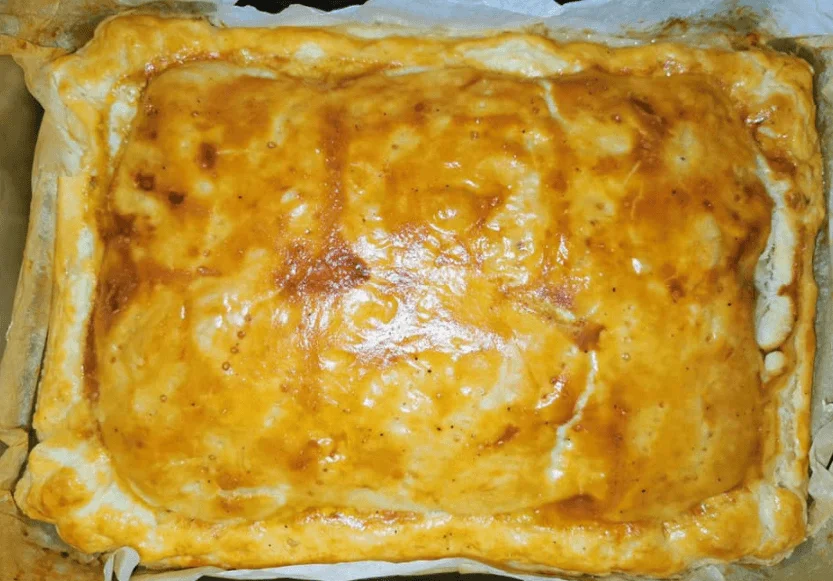 Sformato di salumi e formaggi dorato e filante su piatto di ceramica siciliana