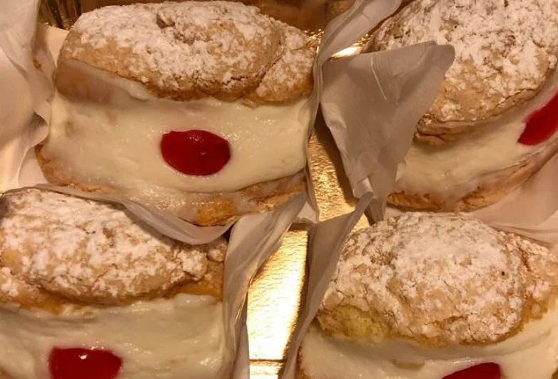 Sospiri di monaca messinesi con crema di ricotta e amarene candite su piatto bianco decorato