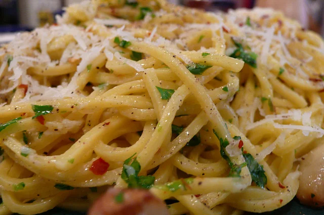 Spaghetti alla chitarra con aglio, olio e peperoncino serviti con prezzemolo fresco e scaglie di pecorino