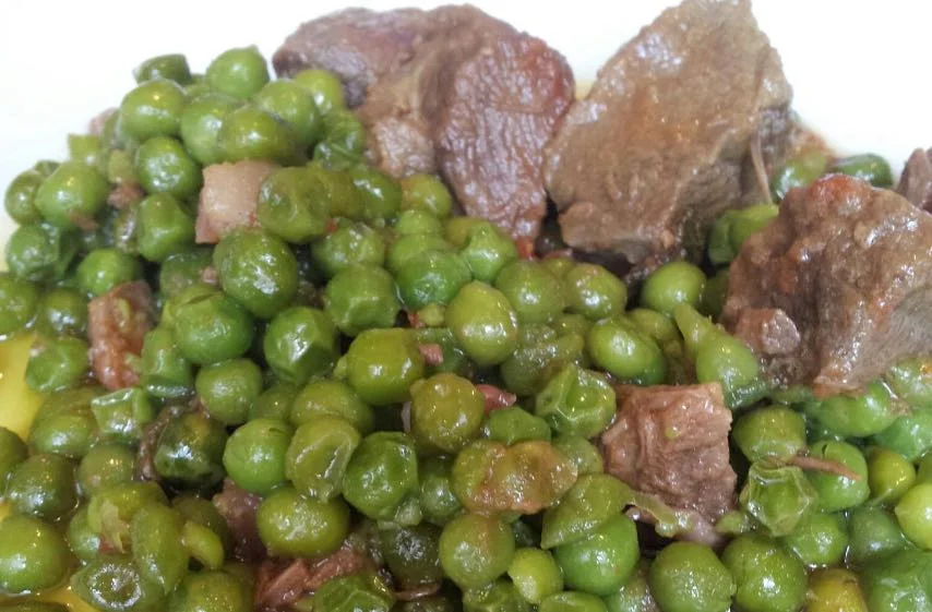 Spezzatino con piselli servito caldo in piatto di ceramica siciliana