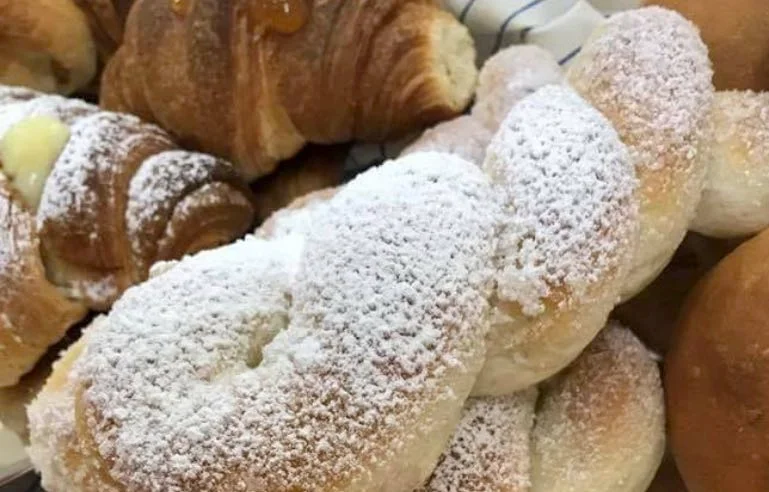Treccine dolci siciliane con zucchero semolato su piatto tipico